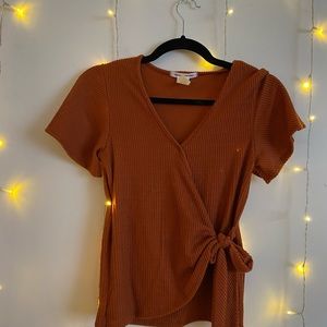 Orange v cut short sleeve shirt with tie in front.